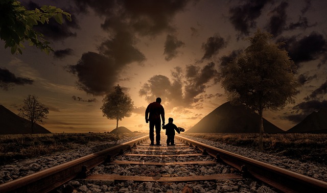 أب وابنه يمشيان على سكة حديدية